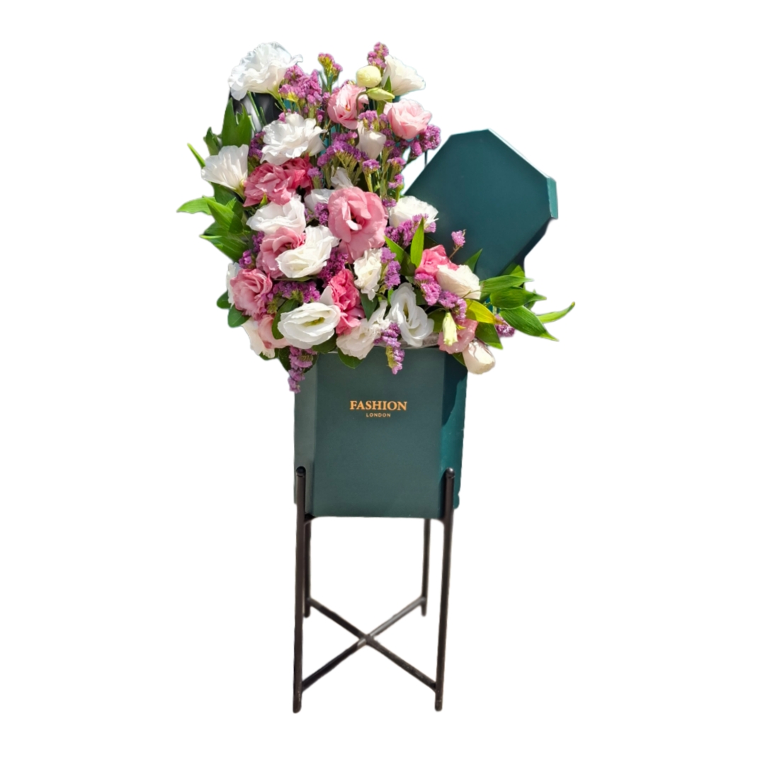 Picsart_25-08-02_16-13-20-677 باکس گل پایه دار مخمل سبز با گل های لیسیانتوس صورتی و سفید و گل های ریز بنفش روی پایه فلزی مشکی با پس زمینه سفید.